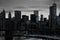 Blue lights shining in black and white night time cityscape with the Brooklyn Bridge and buildings of Manhattan in New York City